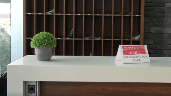 Mostrador de conserjería vacío con cartel de conserje ausente, situación resuelta con servicio remoto Edipro