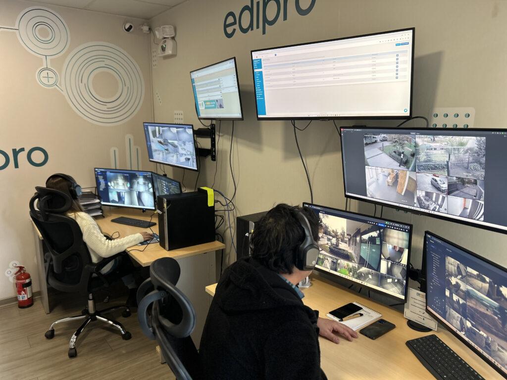 Sala de control con múltiples monitores de vigilancia conectados al sistema de conserjería remota Edipro